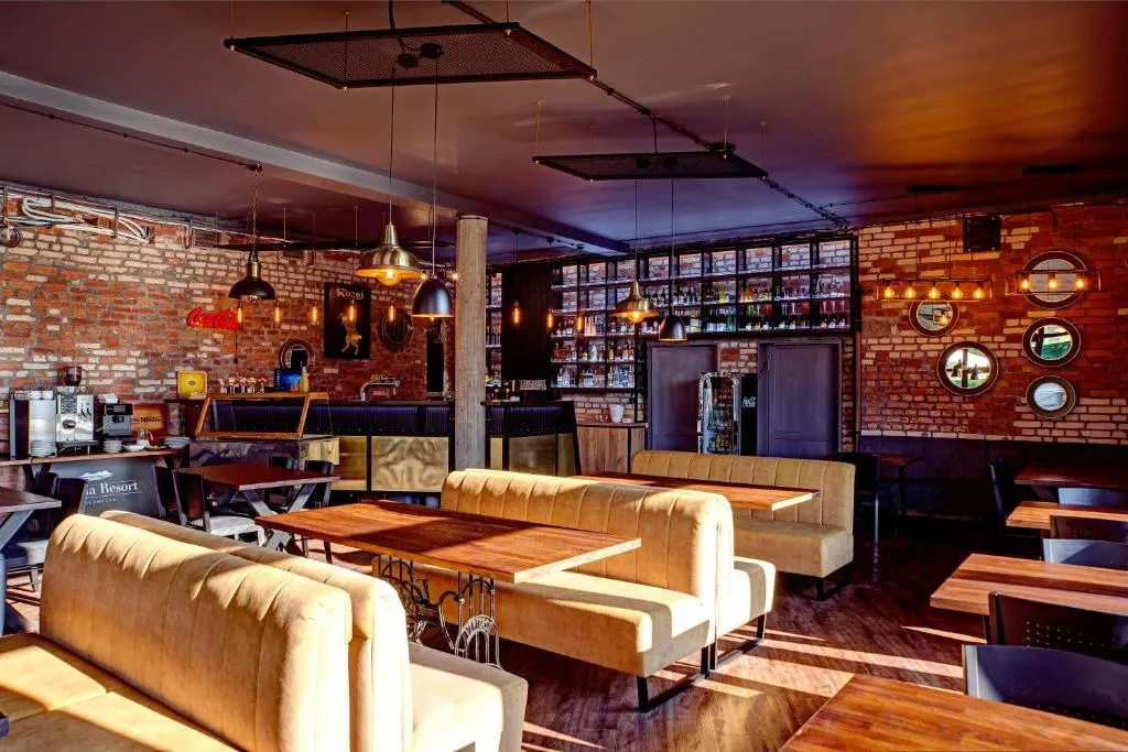 Wnętrze restauracji Loft 18 w Solina Resort w Polańczyku: ceglane ściany, sofy i industrialne lampy