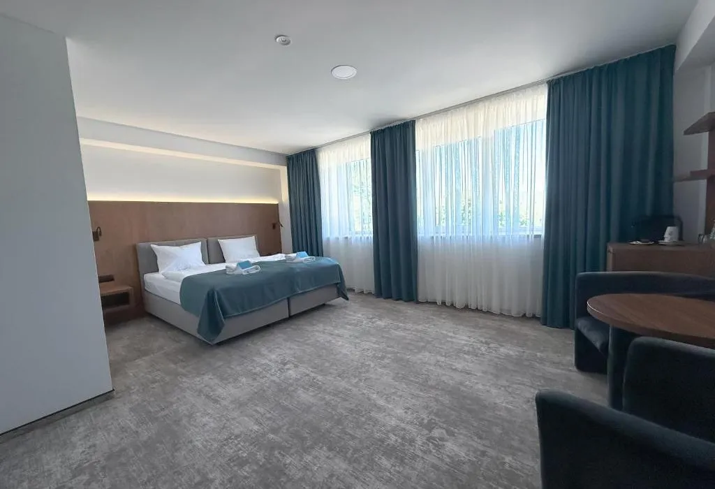 Apartament w Solina Resort – przestronna część sypialna z dużymi oknami i fotelami
