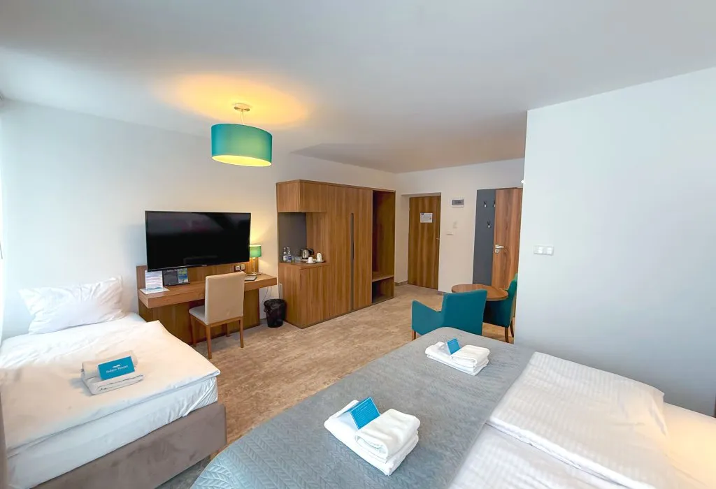 Pokój rodzinny w Solina Resort w Polańczyku z dwoma łóżkami, biurkiem i telewizorem